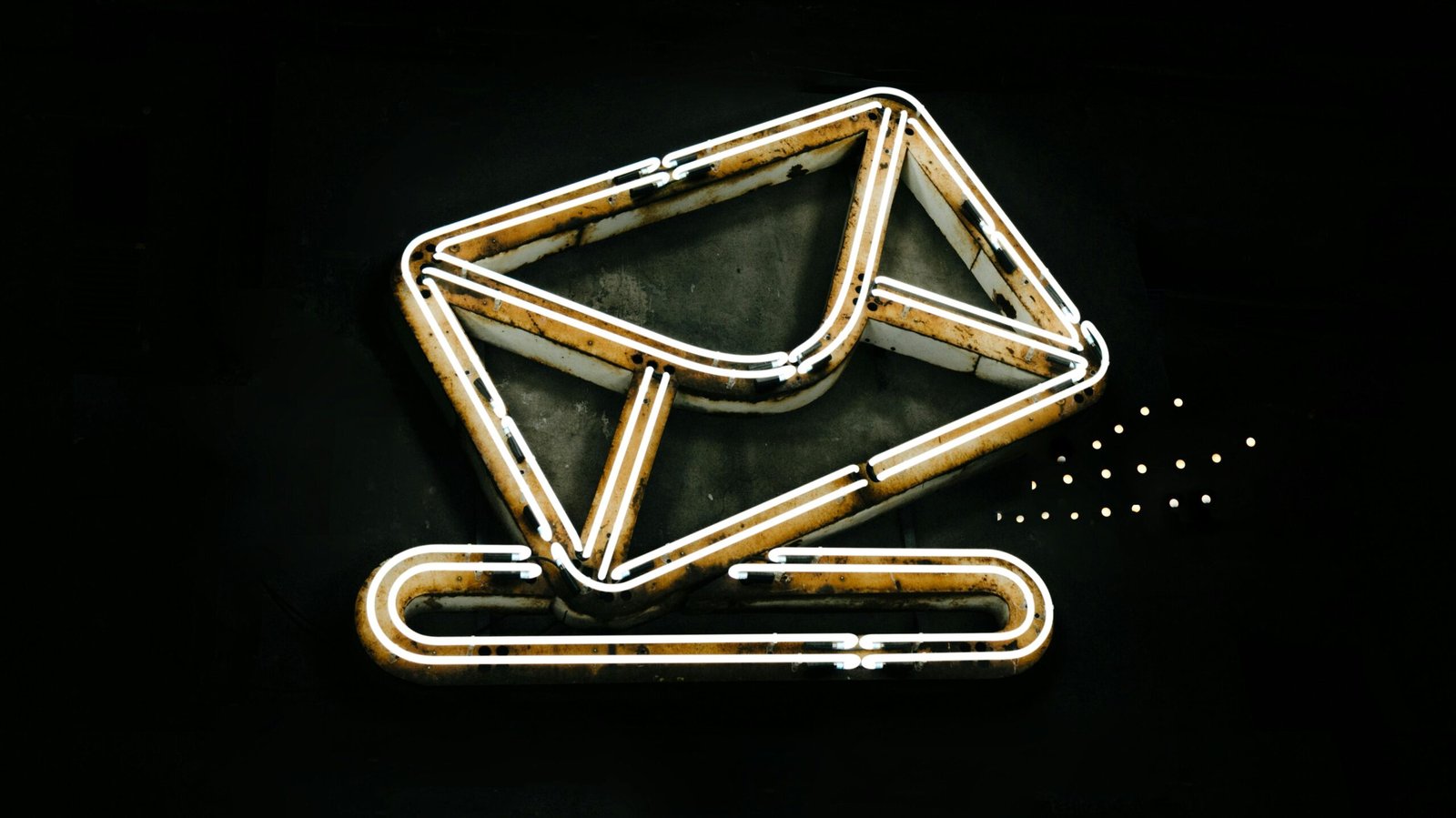A glowing neon envelope symbol against a black background, conveying messaging or email concept.